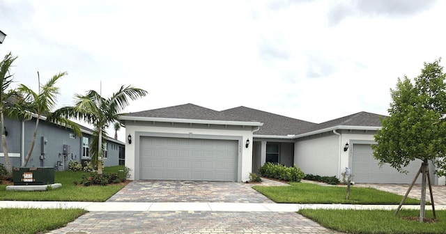 ranch-style house featuring a garage, a front lawn, and central air condition unit