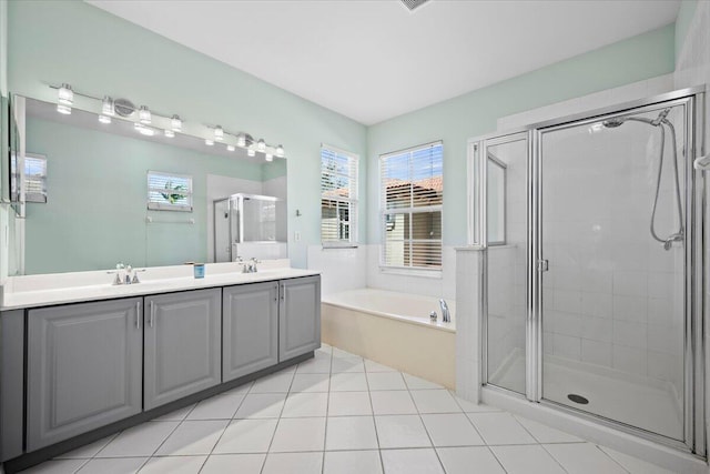 bathroom with plus walk in shower, plenty of natural light, vanity, and tile patterned floors