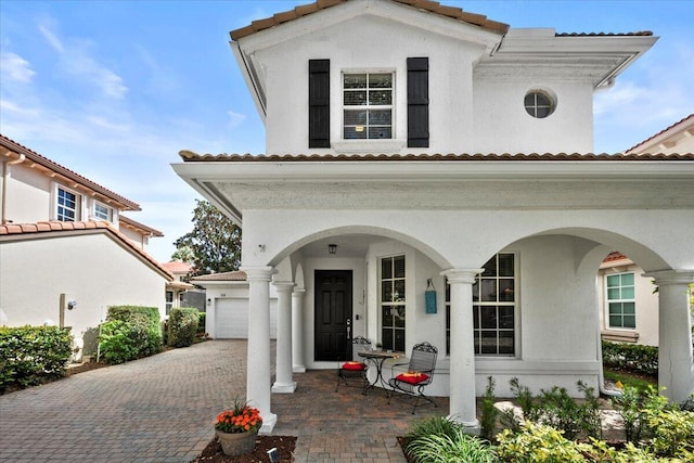 mediterranean / spanish-style house with a garage and covered porch