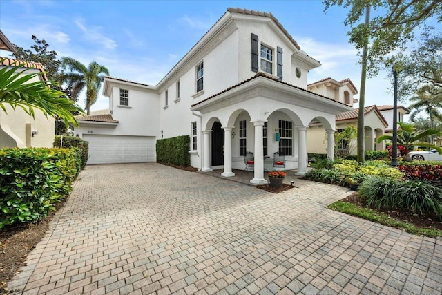 318 September St, Palm Beach Gardens, FL 33410 - mediterranean / spanish-style house featuring decorative driveway, stucco siding, a garage, and a tiled roof