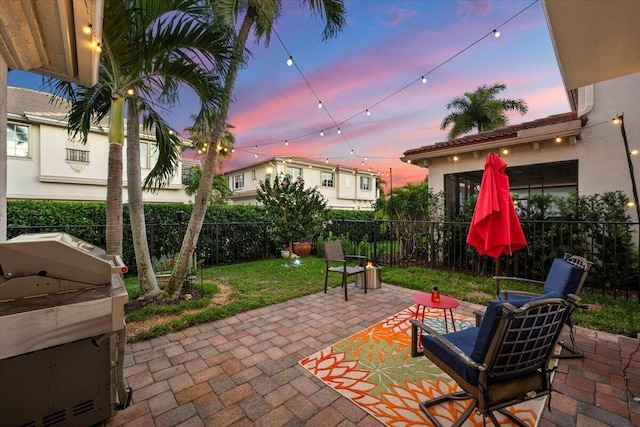 patio terrace at dusk featuring grilling area