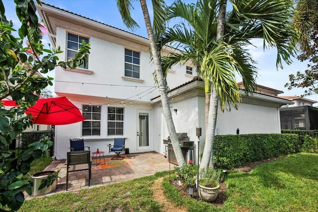 rear view of property with a patio area and a lawn