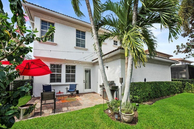 318 September St, Palm Beach Gardens, FL 33410 - back of house featuring stucco siding, a lawn, a patio area, and a tile roof