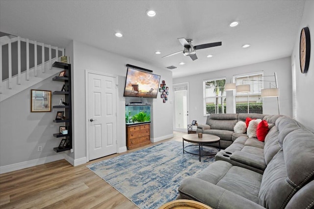 living room with ceiling fan, hardwood / wood-style flooring, and a textured ceiling