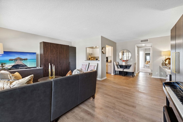 living room featuring light hardwood / wood-style flooring and a textured ceiling