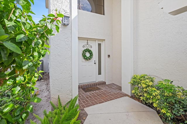 doorway to property featuring stucco siding