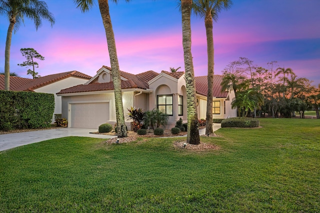 mediterranean / spanish-style home with a garage and a lawn