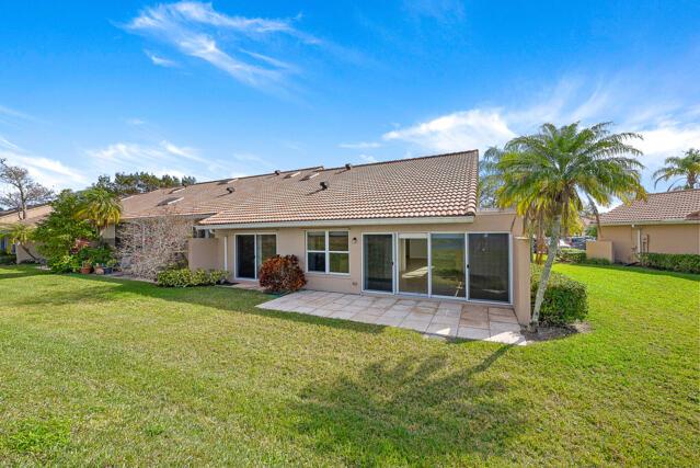 back of property with a patio and a lawn