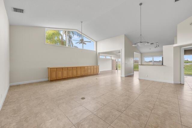 empty room with light tile patterned flooring, ceiling fan, and vaulted ceiling