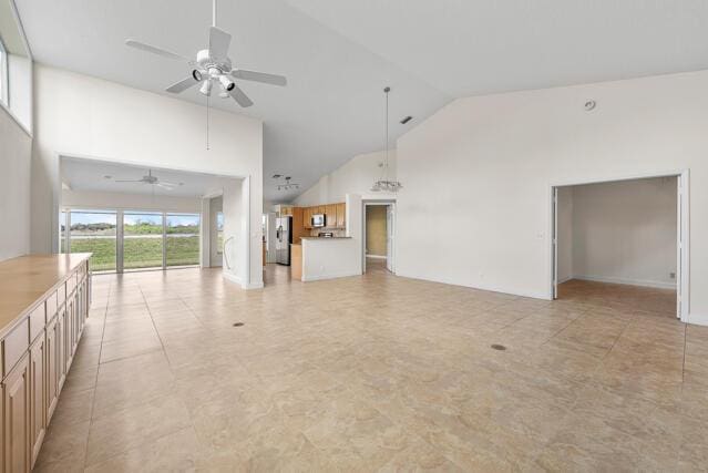 unfurnished living room with high vaulted ceiling and ceiling fan