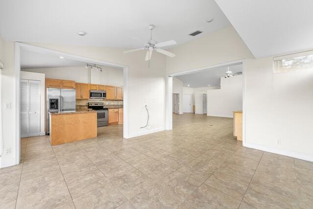 kitchen featuring stainless steel appliances, high vaulted ceiling, and ceiling fan