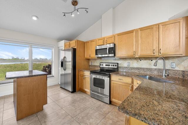 kitchen featuring tasteful backsplash, sink, dark stone counters, and appliances with stainless steel finishes