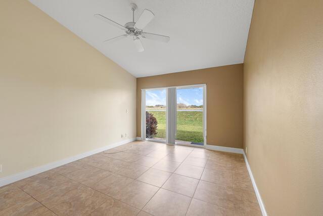 tiled spare room featuring ceiling fan and lofted ceiling