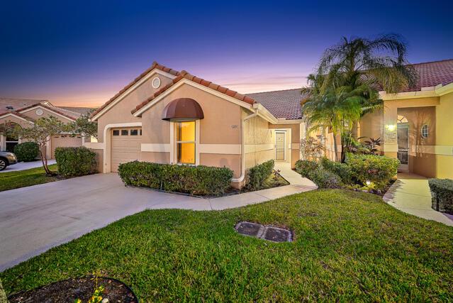 mediterranean / spanish-style home with a yard and a garage