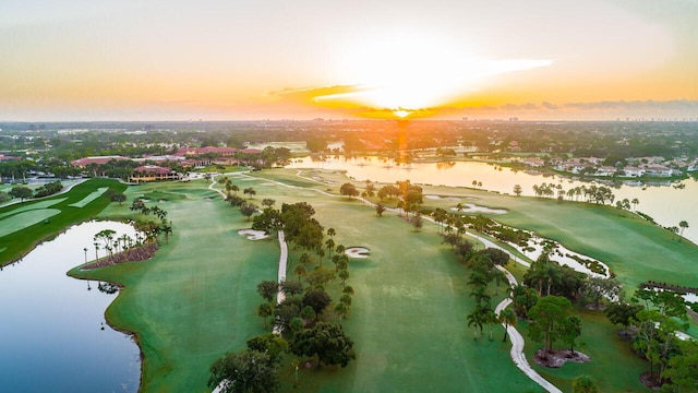 aerial view at dusk featuring a water view