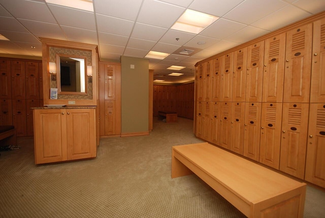 hall with light colored carpet and a paneled ceiling