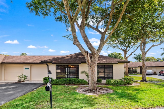 ranch-style house featuring a garage and a front yard