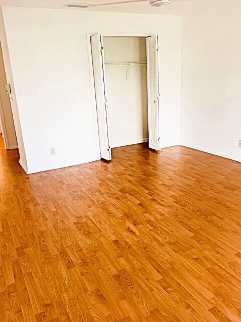 10439 Quailwood Ln Unit B, Boynton Beach, FL 33436 - unfurnished bedroom featuring wood finished floors and a closet