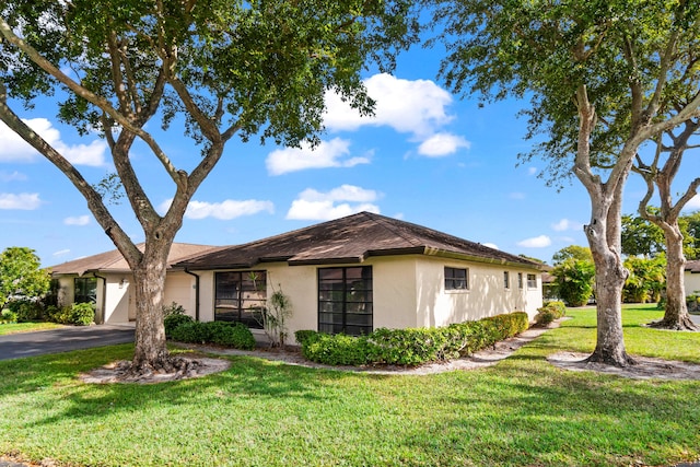 10439 Quailwood Ln Unit B, Boynton Beach, FL 33436 - view of front facade with stucco siding, asphalt driveway, and a front lawn