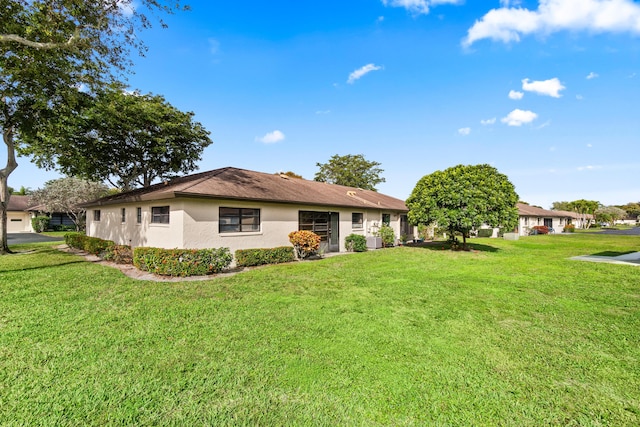 10439 Quailwood Ln Unit B, Boynton Beach, FL 33436 - rear view of property with stucco siding and a yard