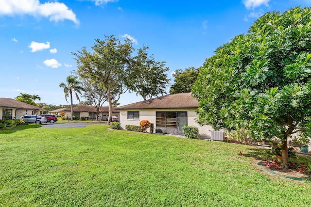 10439 Quailwood Ln Unit B, Boynton Beach, FL 33436 - view of green lawn with central AC and driveway
