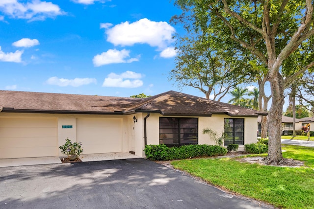 ranch-style house with a garage and a front lawn