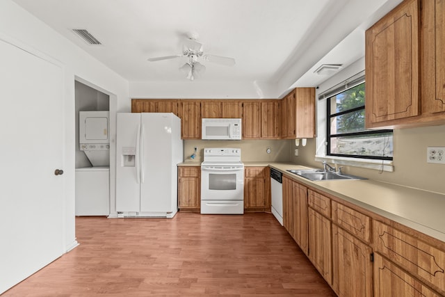10439 Quailwood Ln Unit B, Boynton Beach, FL 33436 - kitchen featuring white appliances, stacked washer / drying machine, a sink, light wood-style flooring, and light countertops