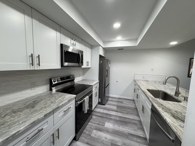 kitchen with white cabinetry, appliances with stainless steel finishes, and a sink