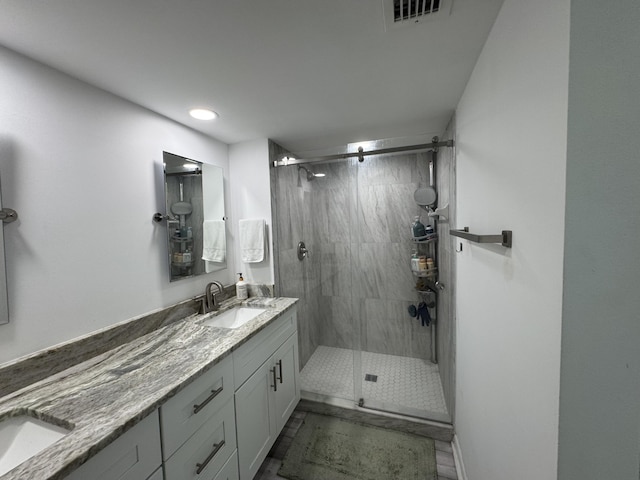 bathroom featuring recessed lighting, double vanity, visible vents, a sink, and a stall shower