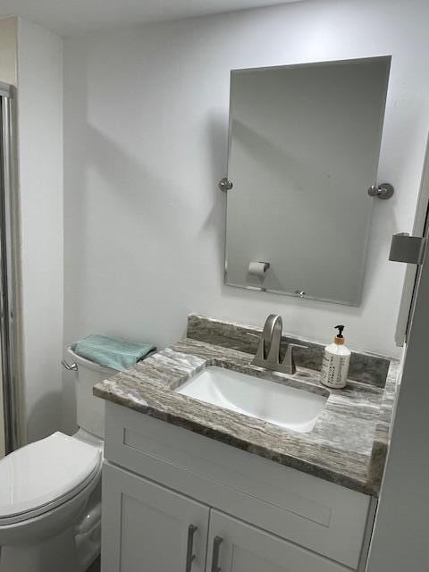 half bathroom featuring toilet and vanity