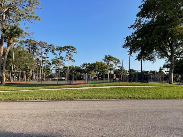 view of community with a tennis court and fence