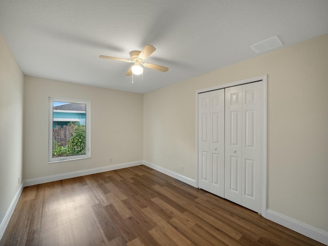 unfurnished bedroom with hardwood / wood-style flooring, ceiling fan, and a closet