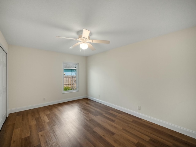 unfurnished bedroom with dark hardwood / wood-style flooring, a closet, and ceiling fan