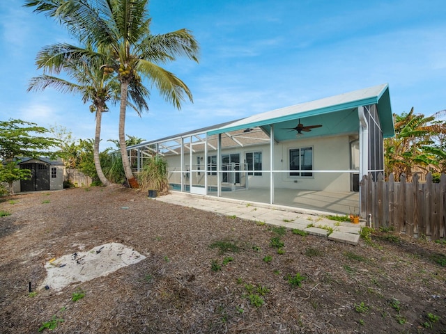 rear view of property featuring ceiling fan, a patio, a storage unit, and glass enclosure