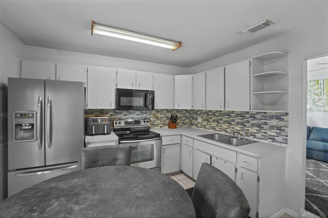 kitchen featuring tasteful backsplash, visible vents, appliances with stainless steel finishes, white cabinetry, and a sink