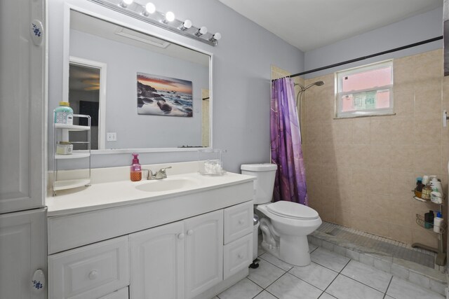 full bath featuring tiled shower, vanity, toilet, and tile patterned floors