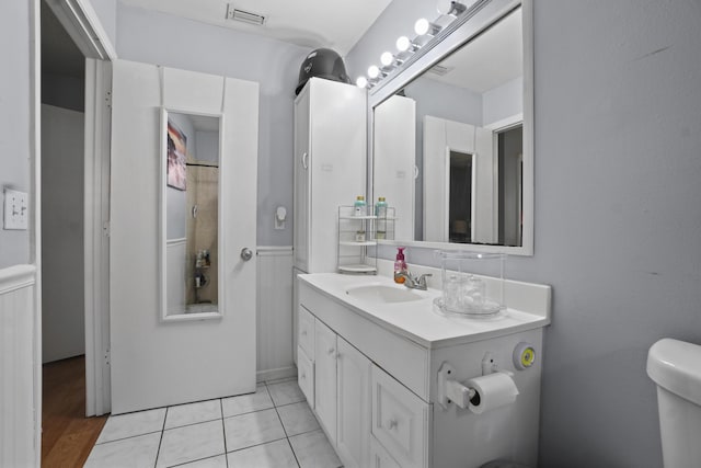 bathroom with toilet, tile patterned flooring, vanity, and visible vents