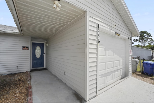 entrance to property featuring a shingled roof and an attached garage