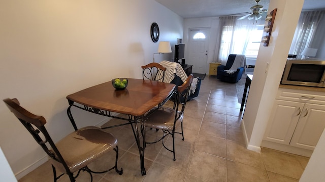 dining space with ceiling fan and light tile patterned floors