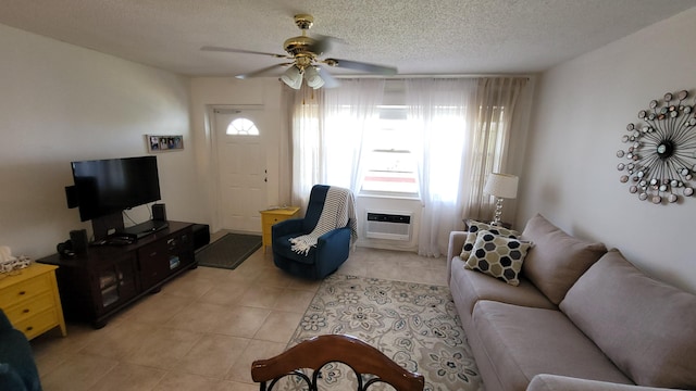 tiled living room featuring ceiling fan, plenty of natural light, a wall mounted air conditioner, and a textured ceiling