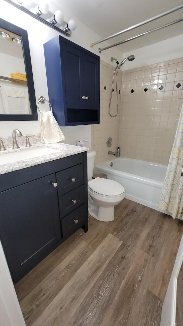 full bathroom with hardwood / wood-style flooring, vanity, toilet, and shower / bath combination with curtain