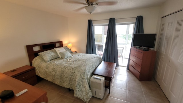 tiled bedroom with ceiling fan and a closet