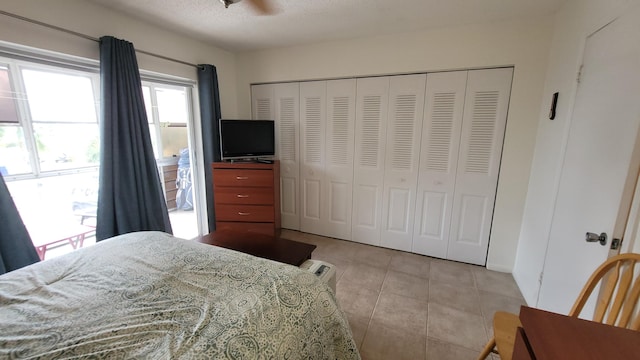 tiled bedroom featuring a closet and a textured ceiling