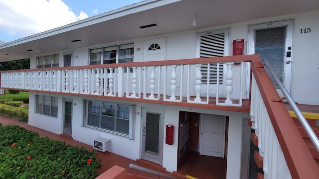 view of front of property with an AC wall unit