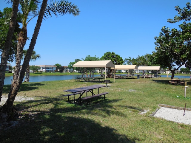 surrounding community with a water view and a yard