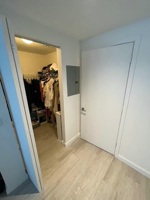 hallway featuring electric panel and light hardwood / wood-style floors