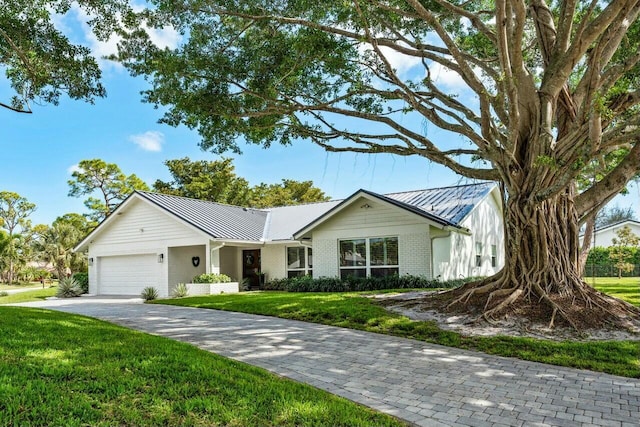 single story home featuring a front lawn and a garage