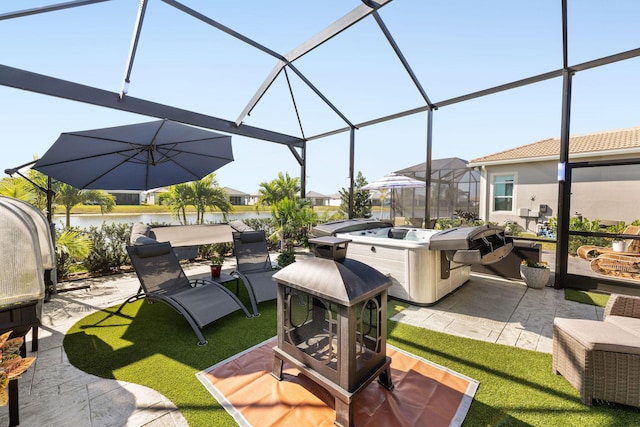 view of patio featuring area for grilling, glass enclosure, and a water view