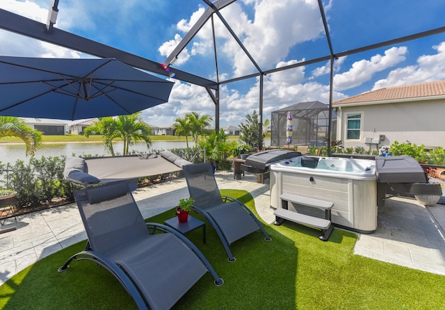 view of patio / terrace with a hot tub, a water view, and a lanai