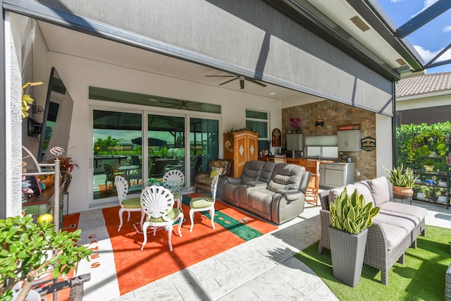view of patio with an outdoor living space, exterior kitchen, ceiling fan, and a lanai
